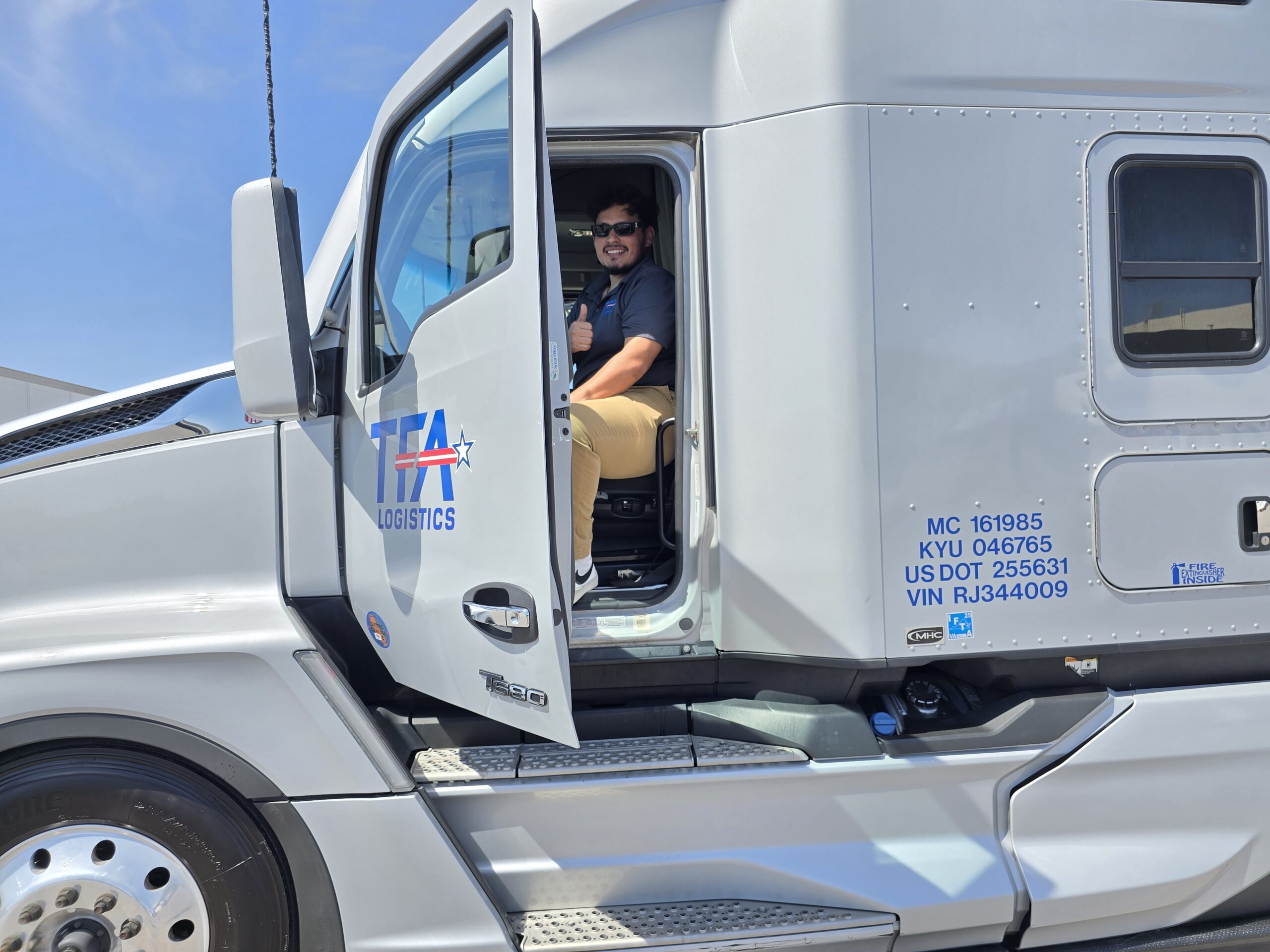 TFA truck driver seated in the truck cab, posing for a photo